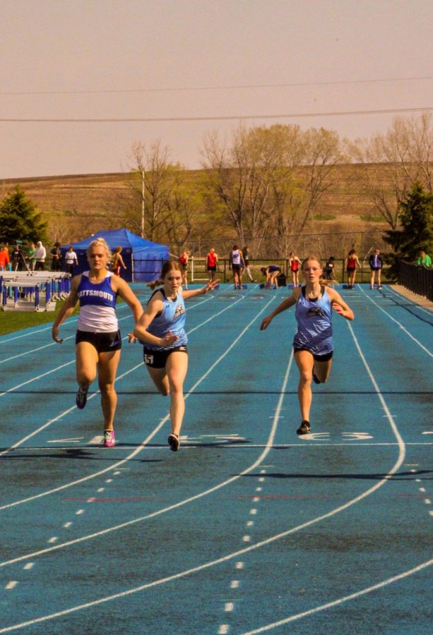 Freshmen sprinting together down the track.