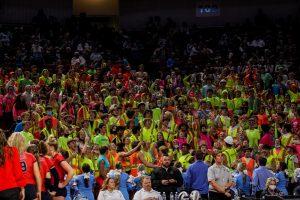 The student section shows support with a neon theme. Hyping up their lady wolves for their second round competition.