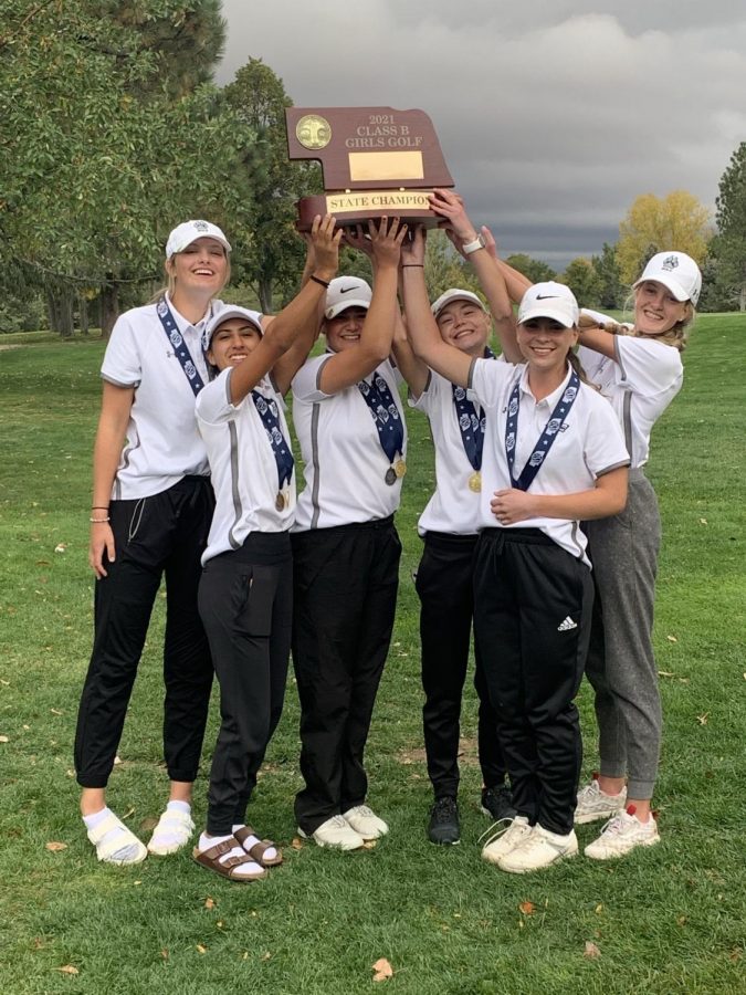 The Elkhorn North girls golf team hoists the golf state championship trophy