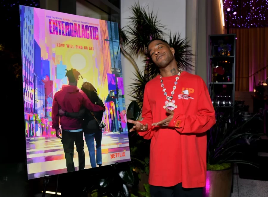 Kid Cudi standing next to the movie poster of his animated special. 