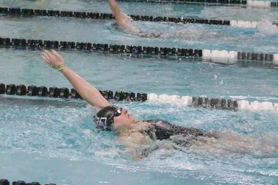 Senior Sadie Jacobson strokes backwards during the 200 Yard IM. Jacobson was looking to improve her time and earn points towards helping her team win the duel against Bellevue West. 