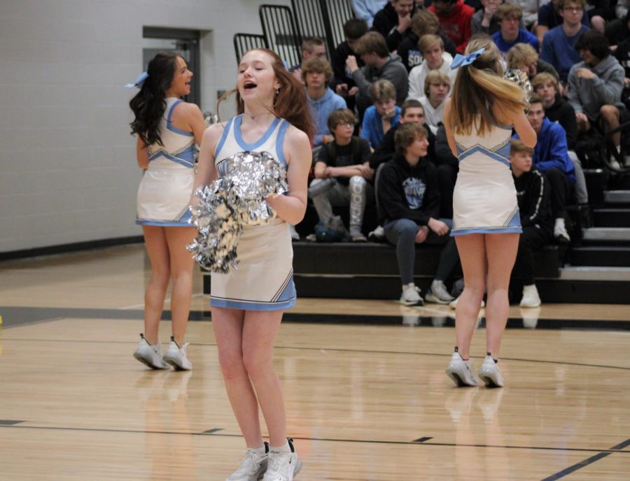 Alie Dixon jumps in the air while cheering at the beginning of the pep rally. Dixon helps to hype up the crowd as the students get settled into the bleachers.