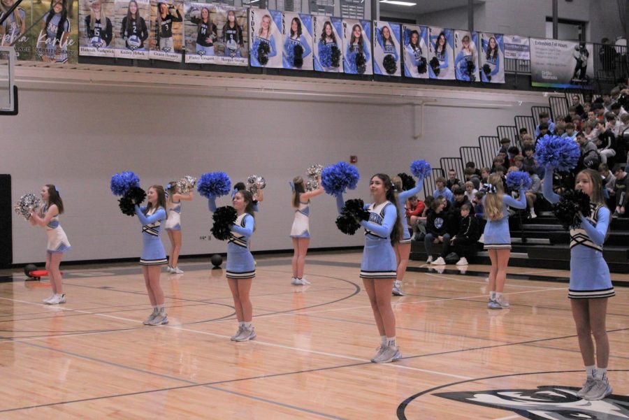 The cheer and dance teams cheer in the gym together during the pep rally. They performed together at the beginning to get the students ready for the pep rally.