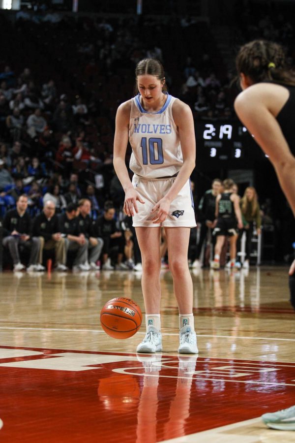 Thompson dribbles the ball to prepare for her free throw shot. She gets into position to make the shot.