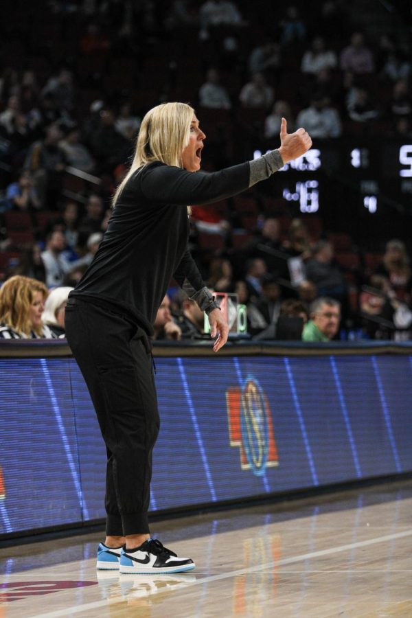 Standing on the sidelines, coach Prince yells and gestures to the players about what she wants them to do. Prince encourages them to do their best and score as many points as possible.