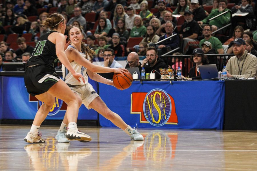 Player Grace Thompson works hard to guard the ball from her opponent. She successfully keeps the ball from getting into the Skutt players hands.