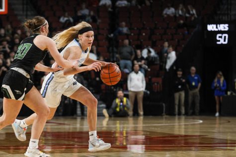 Prince tries to dribble around her opponent as she makes her way down the court. The Skutt player tries to grab the ball as Prince dribbles past her.