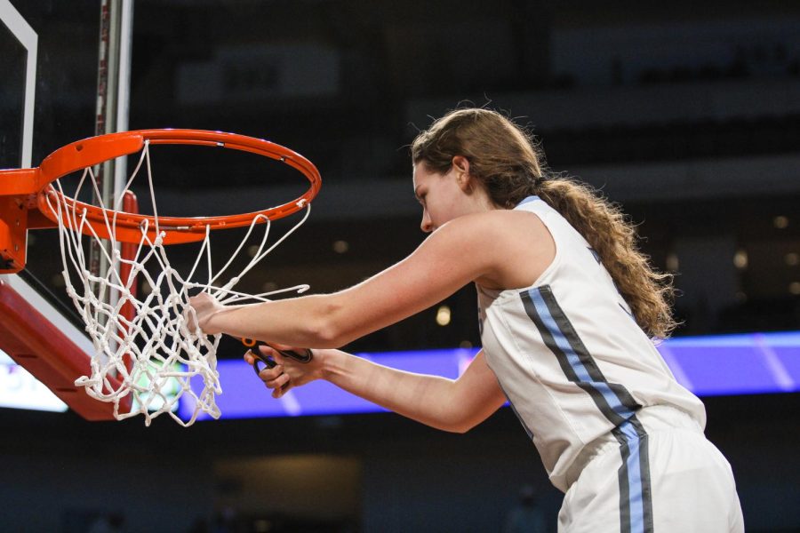 Junior Mckenna Murphy cuts the net at Pinnacle Bank Arena after winning the Class B State Championships.