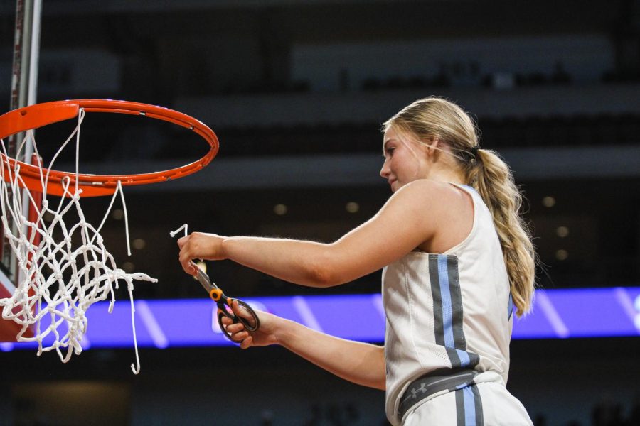 Reese Booth cuts the net at Pinnacle Bank Arena after winning the Class B State Championships.