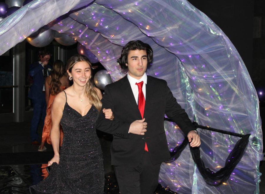 Senior Jad Almazloum and guest link arms as they enter prom.
