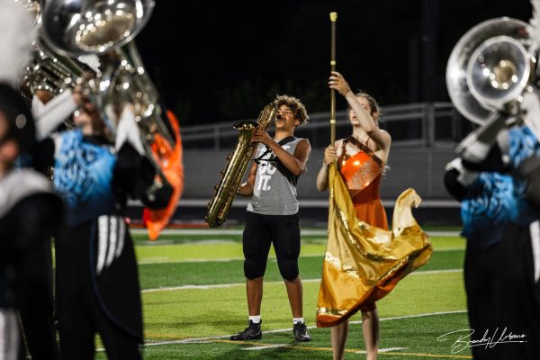 Sophomore Christian Schlott performs on the baritone saxaphone with the rest of the marching band.