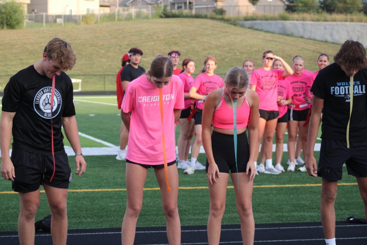 Students from the stands compete in a minute to win it game during half time on September 13, 2023. The two powder puff teams go over which routes they are going to run in the meantime. 