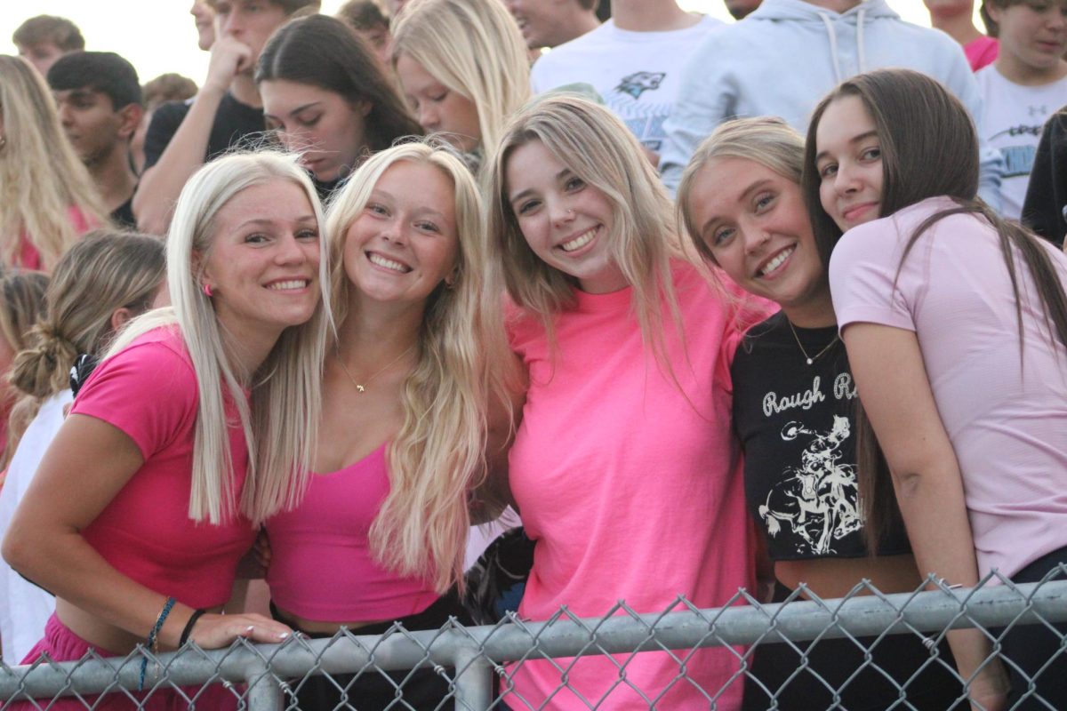 Seniors Kamerin Turner, Ashlyn Caniglia, Paige Deveney, Reily Miller and Amya Warren support the girls in the stands on September 13, 2023. The theme for the night is pink out. 