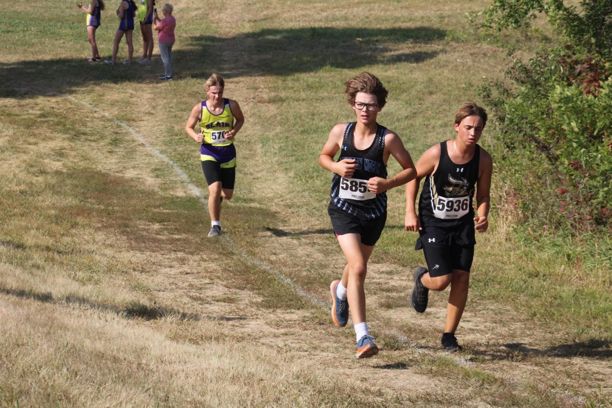 Sophomore Wyatt Sledge pushes past competitors up the Mount Michael hill.  He looks to the side at his mom cheering him on.