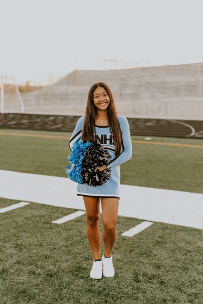 Freshman Elle Jones stands on the Elkhorn North football field for cheer pictures.  Although cheer practices on the field at Elkhorn North, they cheer for games at Elkhorn high.