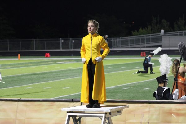 Lacy Mehaffy facing the crowd as she is getting ready to conduct the band through their half-time performance at a football game.