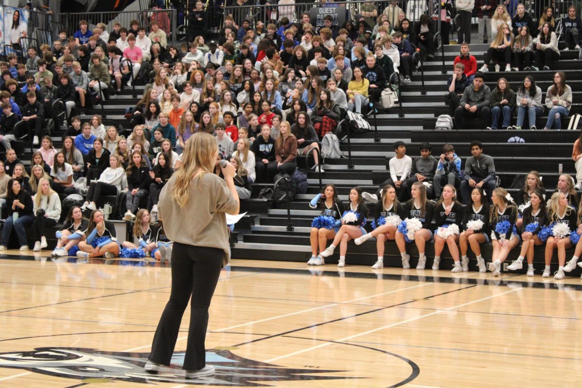 Senior Ava Johnson speaking at the winter pep rally. She tells the student body about the upcoming Pack Nights during the winter pep rally on Dec. 8th 2023.