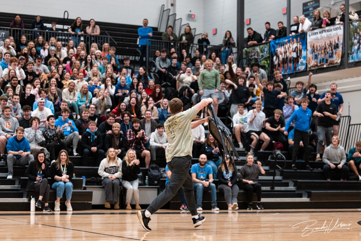 Senior Jayse Munter runs with the final chair in musical chairs. He was the winner of the game at the winter sports pep rally on Dec. 8th 2023.