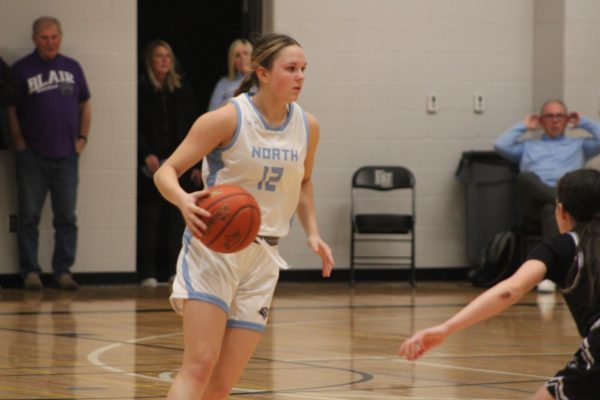 Junior Kara Kudlacz (12) dribbled the ball down the court to the scoring hoop. The game was on the 25th of January, 2024, a Thursday.