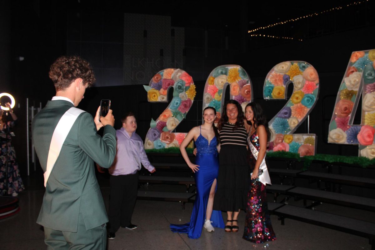 Junior Tyler Nietfeldt, takes picture of juniors Ally Lawrence and Chelsea Mahloch with junior class board sponsor, Reyne Armbrust at prom on April 13, 2024. Ally and Chelsea both have Armbrust in class for Chemistry. 