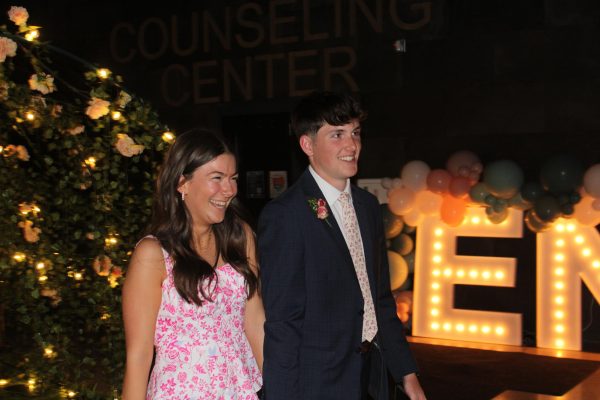 Senior Sarah Spencer and her date, Asher Robinson, walk into prom on April 13, 2024 with smiles on their faces. Both were a part of their school cross country team. 