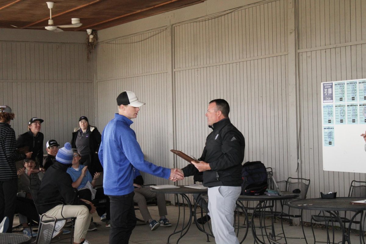 Zach Biegert (11) accepts the team plaque and his first place indivdual medal at the Blair invite on April 19, 2024. Biegert won a three-way playoff hole to win.