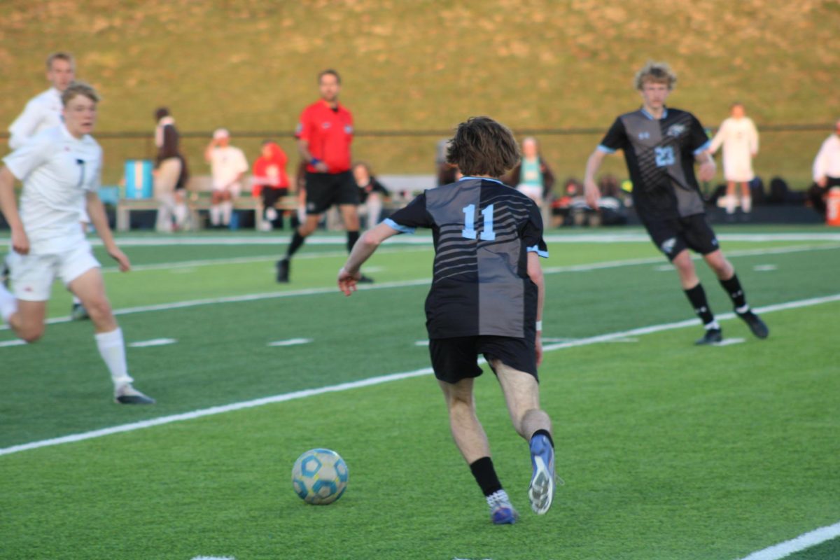 Freshman Zac Keenan (11) running to kick the ball. He passed it to Sophomore Kason Krings (23) at the game against Norris on Tuesday, April 23rd. 