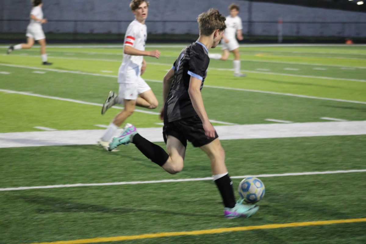 Freshman Camden Hibbard (5) dribbling the ball after he got put in during the second half of the game. The wolves won 4-0 against Norris at their game on Tuesday, April 23rd. 