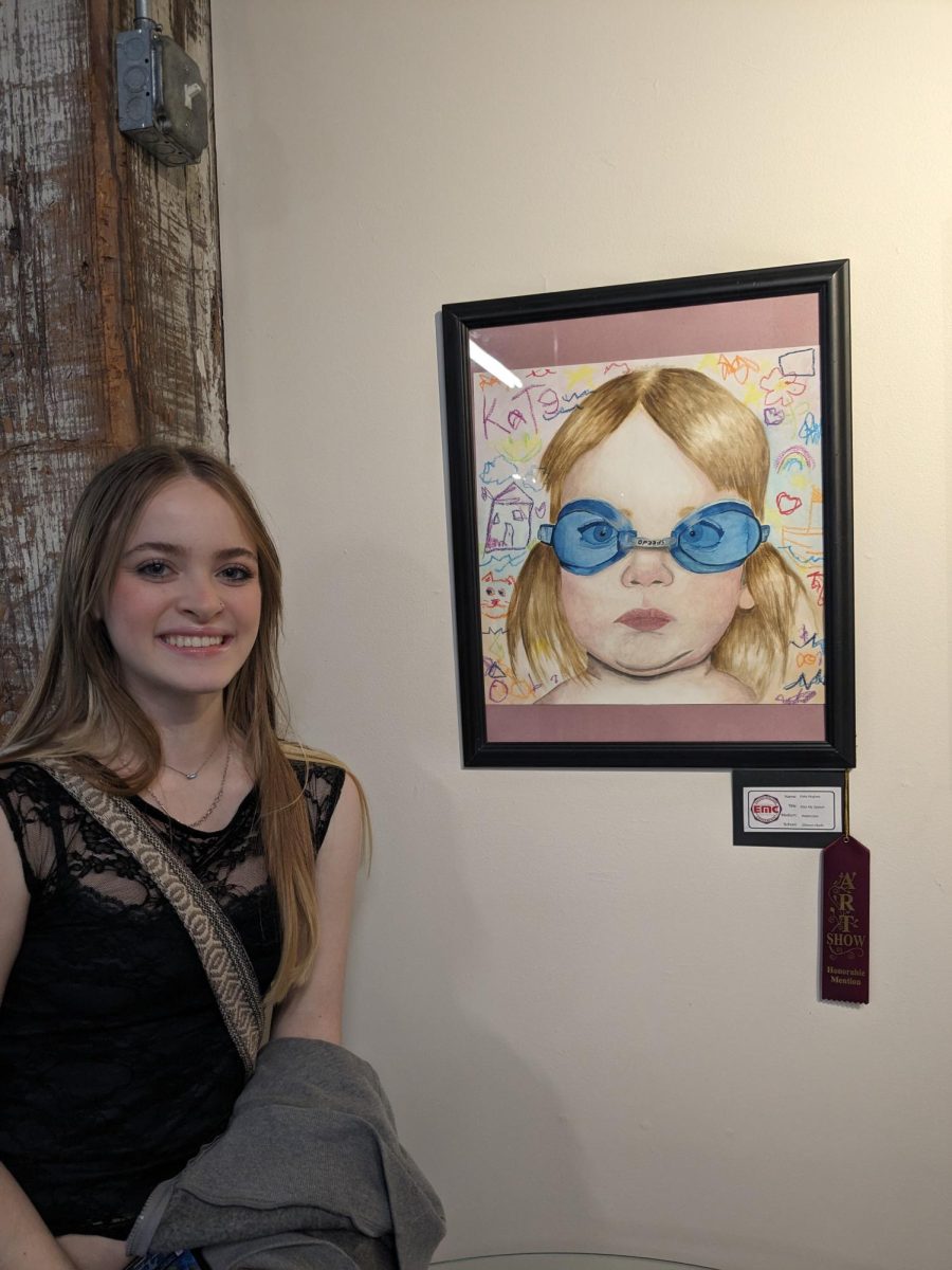Senior Kate Hughes stands next to her artwork titles Kiss my Splash which was displayed at the EMC art show on April 17th, 2024

Photo credits: Madeline Rosonke
