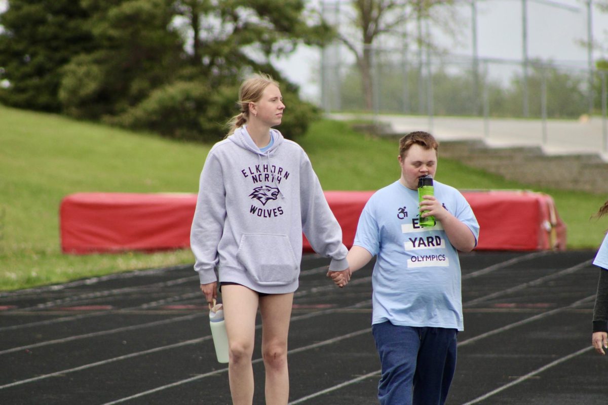 Junior Emma Whalen (left) and Junior Bittner (right) holding hands as they walk around the track. They complete their second lap together on May 3, 2024.