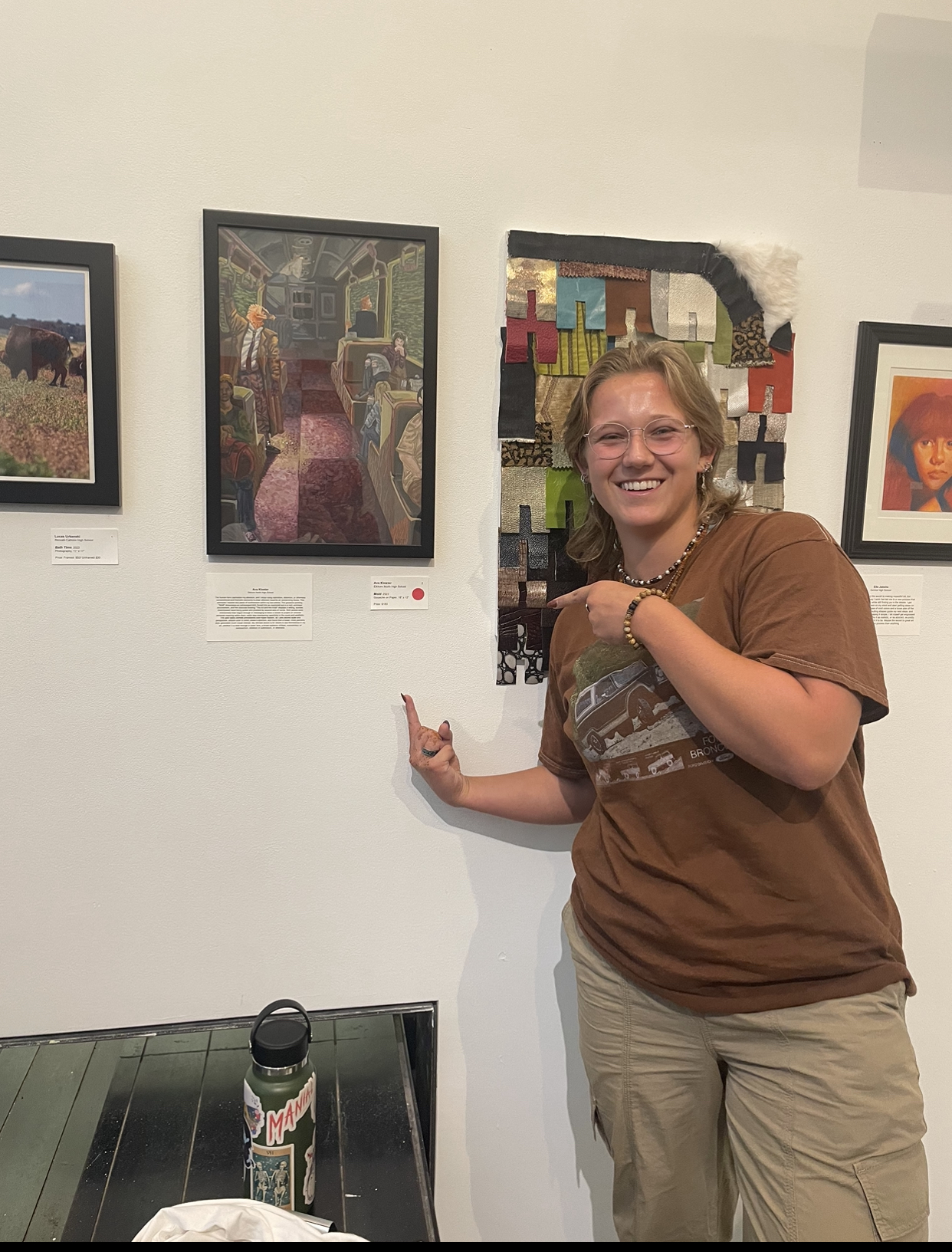 Junior Ava Kloster poses next to her artwork