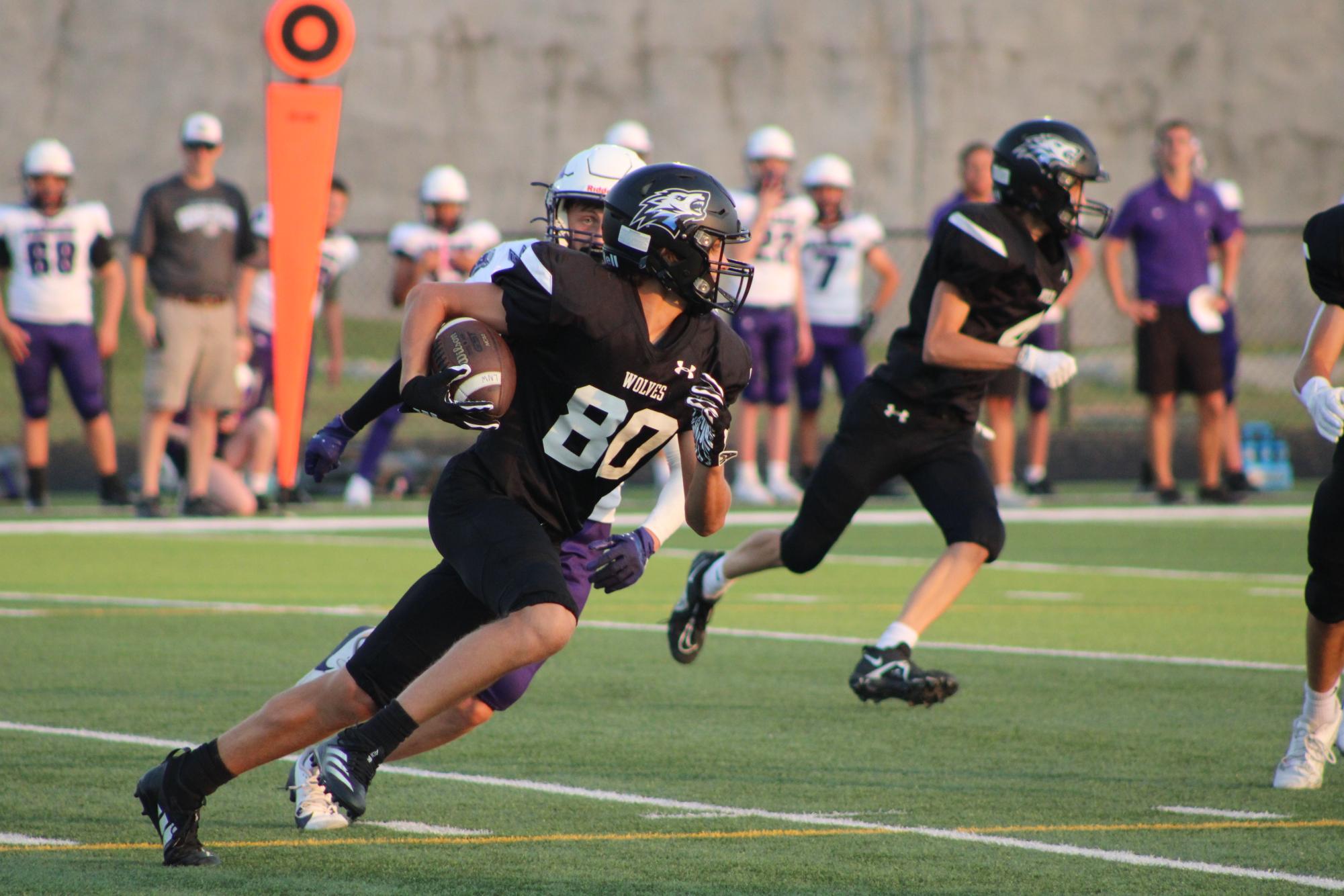 Freshman Connor Wurdeman (80) runs the ball. Wurdeman intercepted a pass during the second quarter of the game on Sept. 12, 2024.