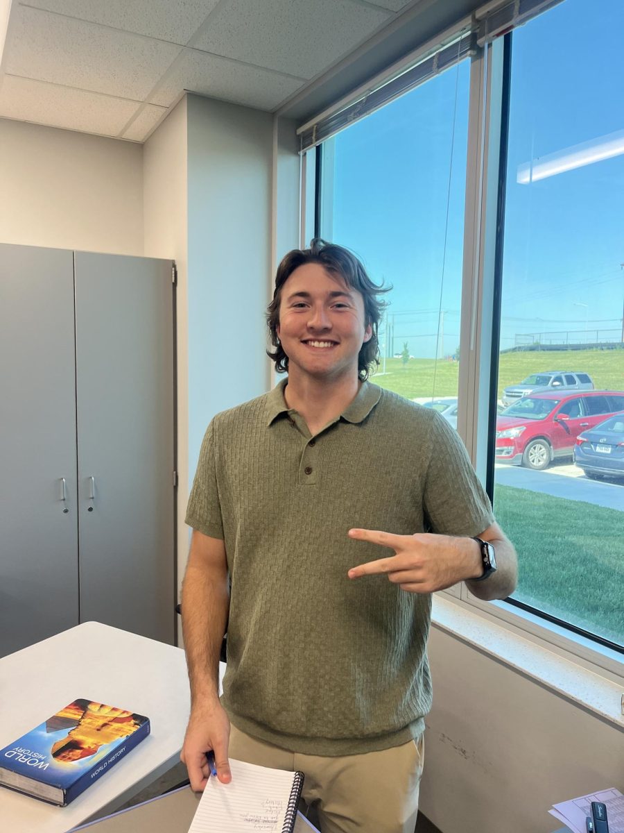 Mr. Jake Aitken, World History teacher, smiling in his classroom.