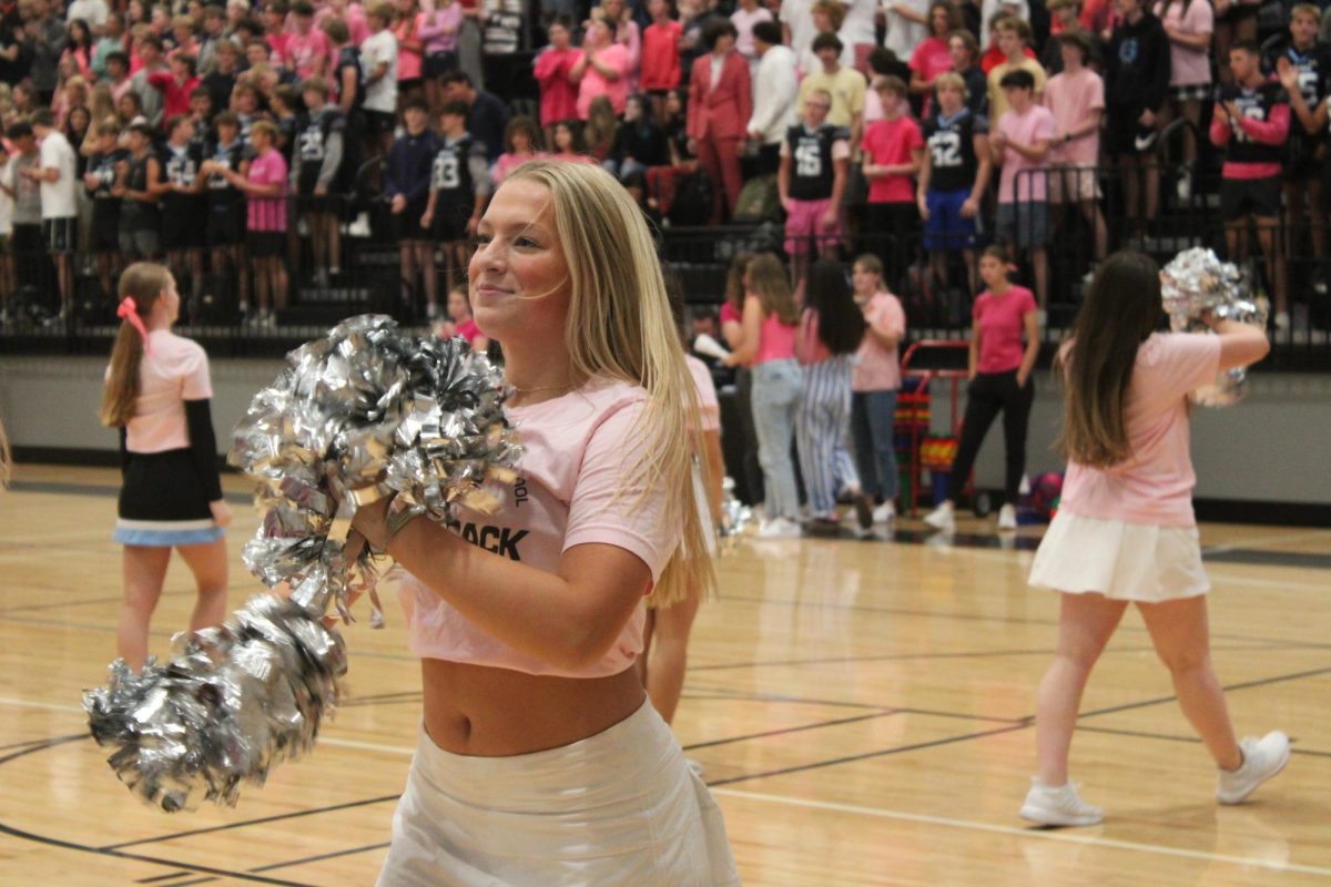 Freshman Avery Crom dances in front of the freshmen student section. Crom looks at the group of high schoolers with a smile. 