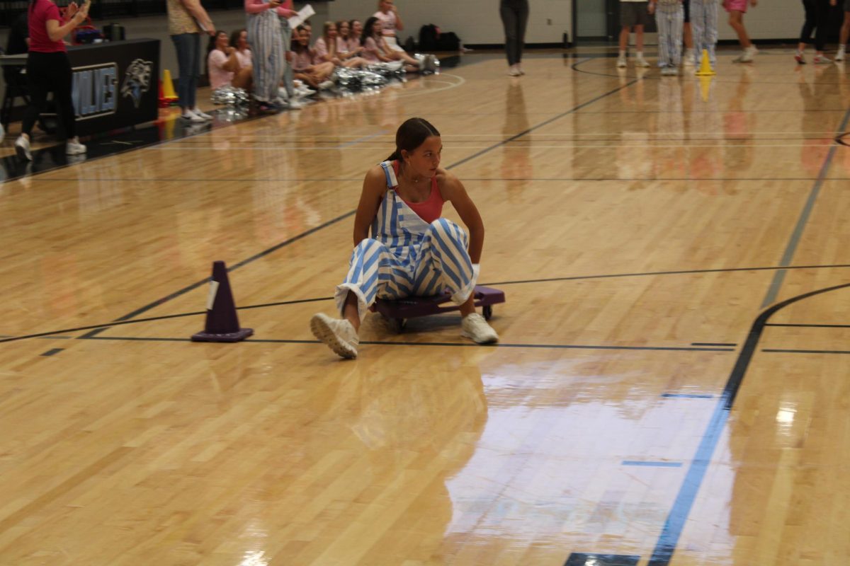 Senior Hannah Nosal glides on a scooter during the scooter race. Seniors won the eventful race. 