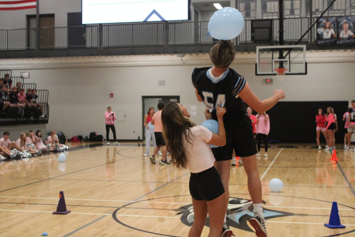 Juniors [left to right] Asher Christo and Aubrey Phonephakdy detach from the rest of the group. Christo attempts to prevent the balloon from touching the gym floor. 