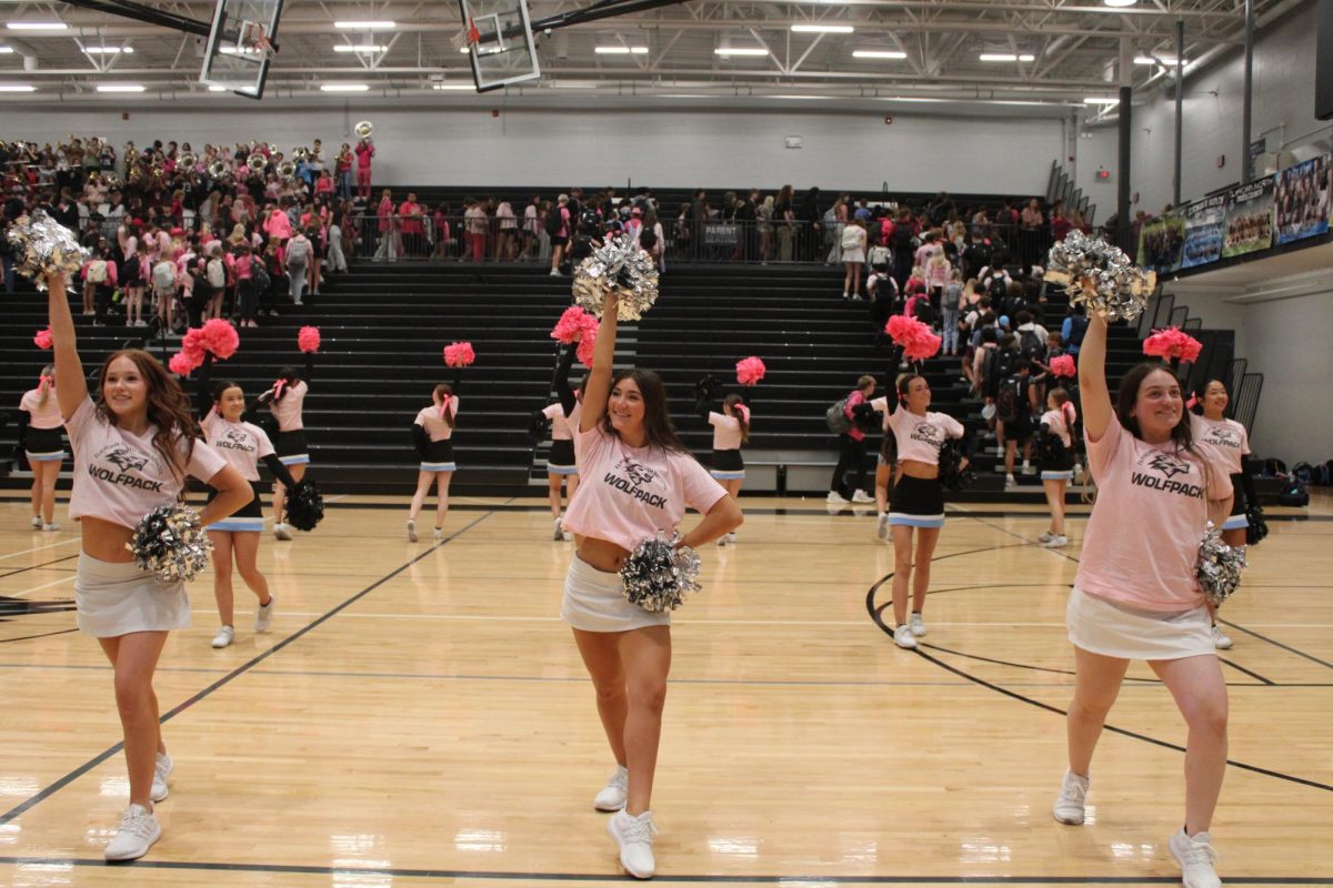 Juniors [left to right] Alison Dixon, Cosette Kaminski, and Kahlen Aurich perform in front of the junior section after the pep rally. They continued until all students and staff exited the gym.