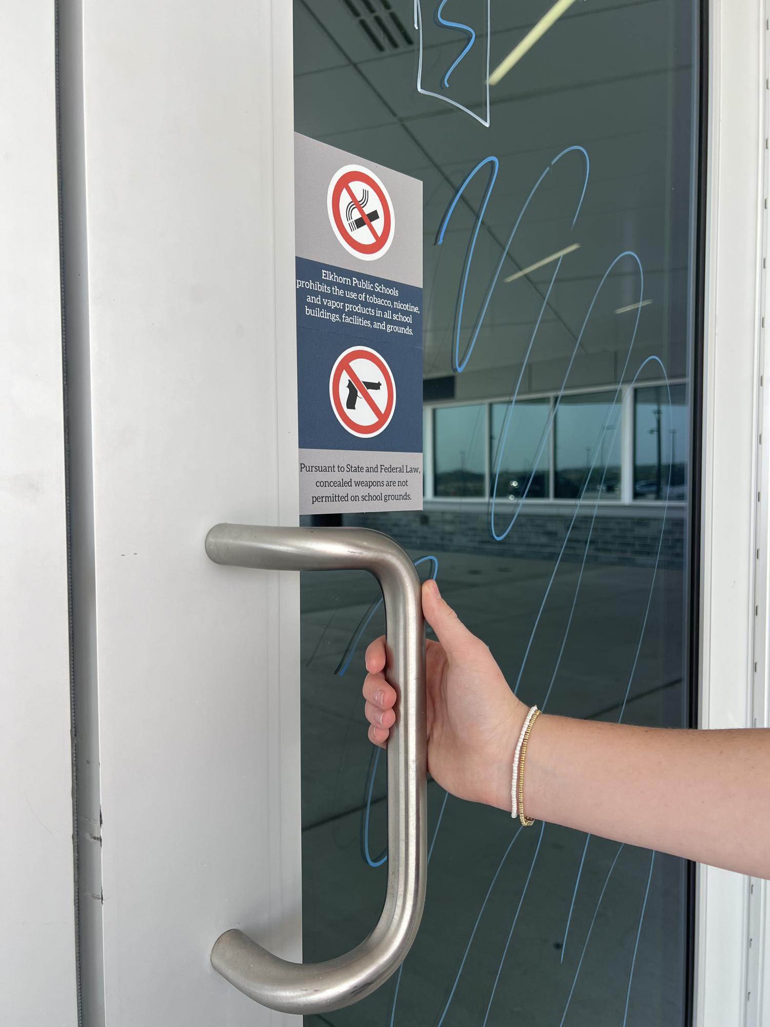 Elkhorn North students enter school doors with a ‘no gun’ sticker posted. The stickers were put up during the 2023-2024 school year. 