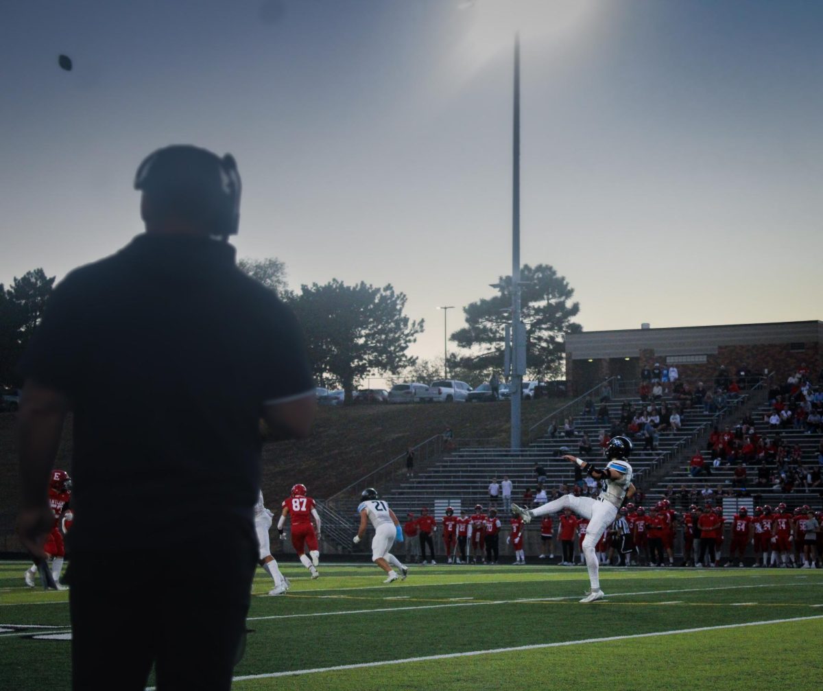 Sam Huff (50) kicks a field goal. Coach Dunn was watching from the sidelines.