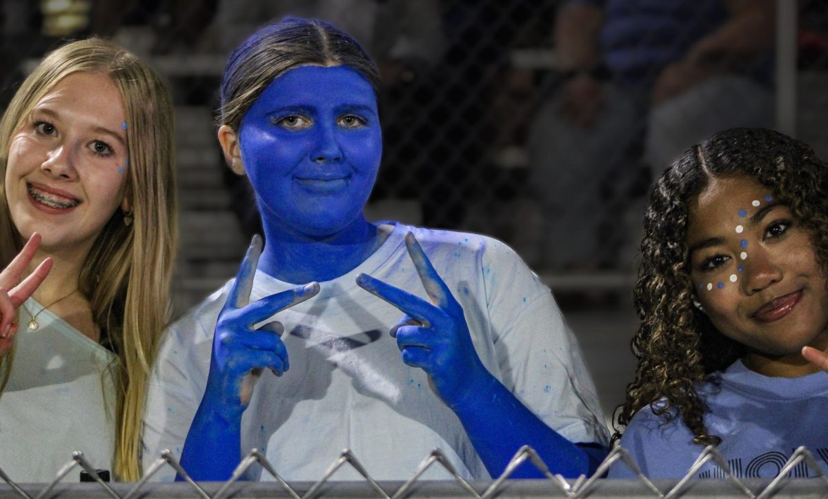 (Left to Right) Sophomores Lauren Wallace, Laela Ness, and Jade Young pose for a photo. Ness went full out for the blue-out theme.