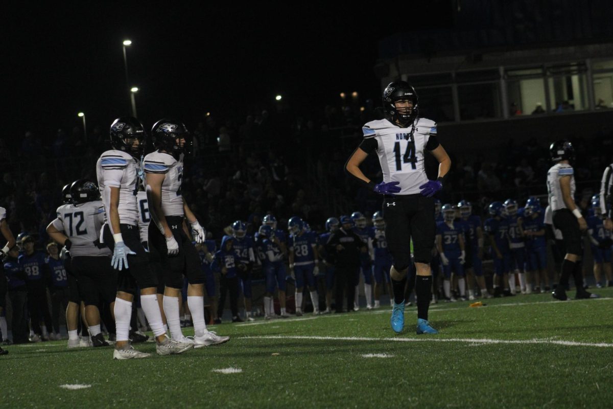 Senior Kendall Gragert looks to the sidelines for advice from his coaches after a flag is thrown. Once he got the signal from the coaches, he lined up for the next play.