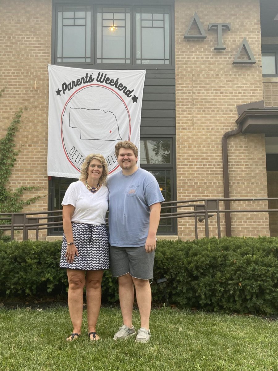 Joshua Hoins stands in front of his fraternity house with his mom. He went to Nebraska Lincoln and was president of his house.