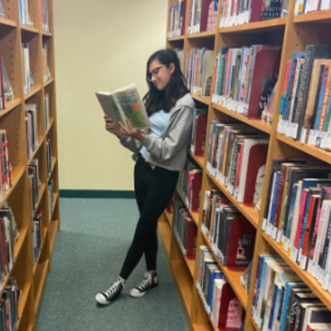 Golej stands in a local bookstore and reads a book from the bookshelf next to her. She used the book to better understand how to edit her novel. Photo coutesy of Amala Golej