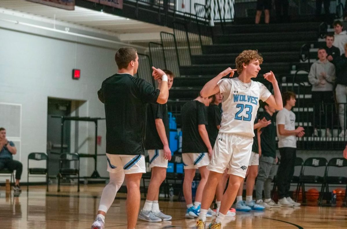 Sophomore Kellen Murphy completes his walk-up handshake with junior Ethan Beachy before their game against Hastings. The Wolves took the win to continue to the EMC championship game.