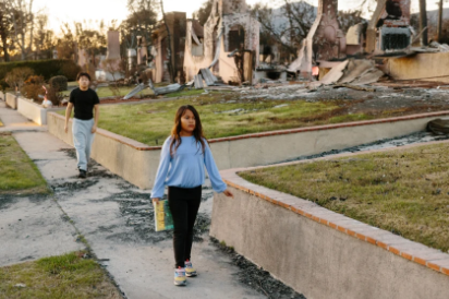 Siblings who are victims of the fires walk down the street of their neighborhood. Photo courtesy to Stella Kalinina for NBC News.