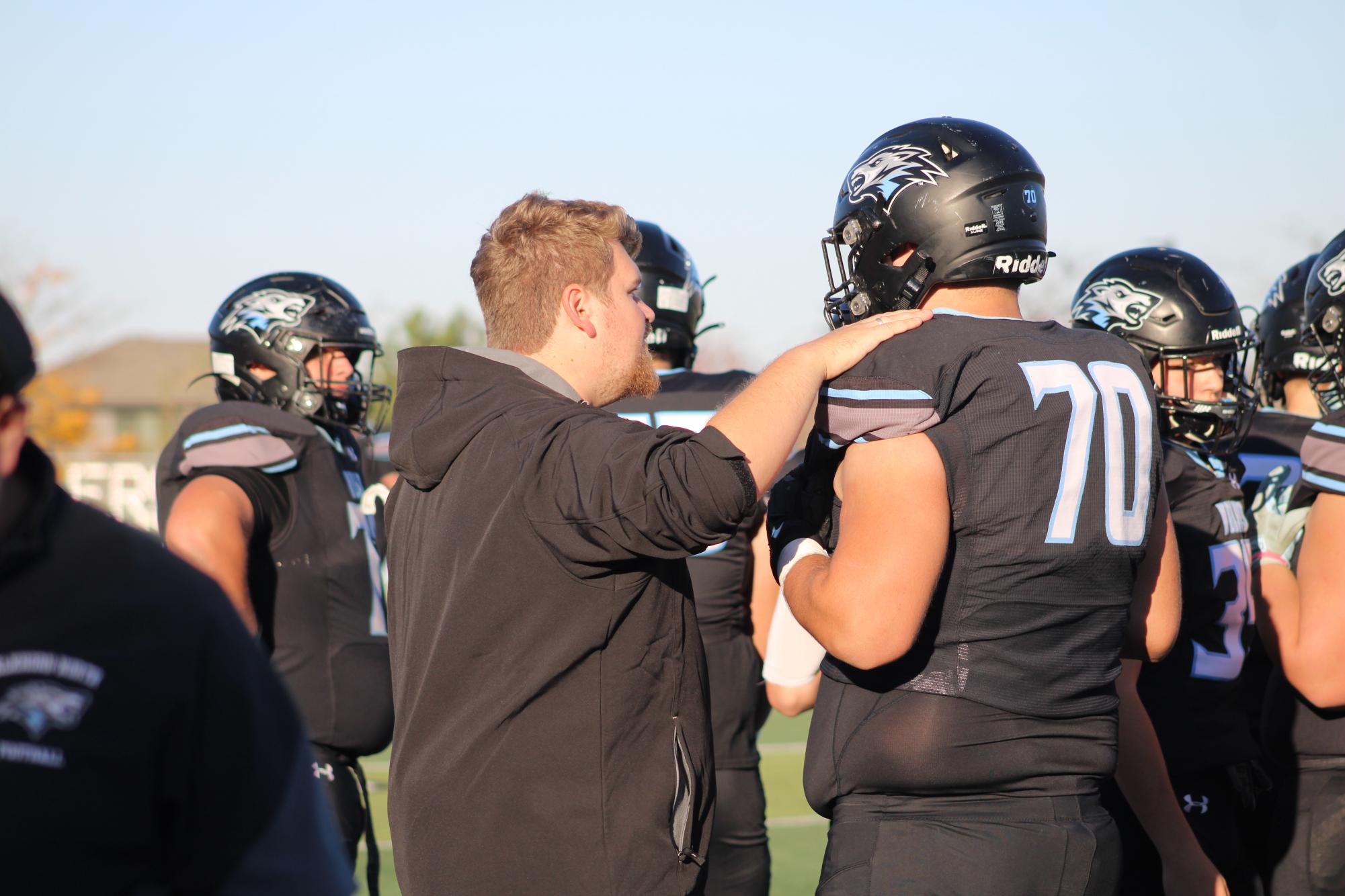 Assistant coach Josh Hoins talks to senior Jayden Kohnekanp after a play. The wolves beat Elkhorn High 35-14 on November 1, 2024.  