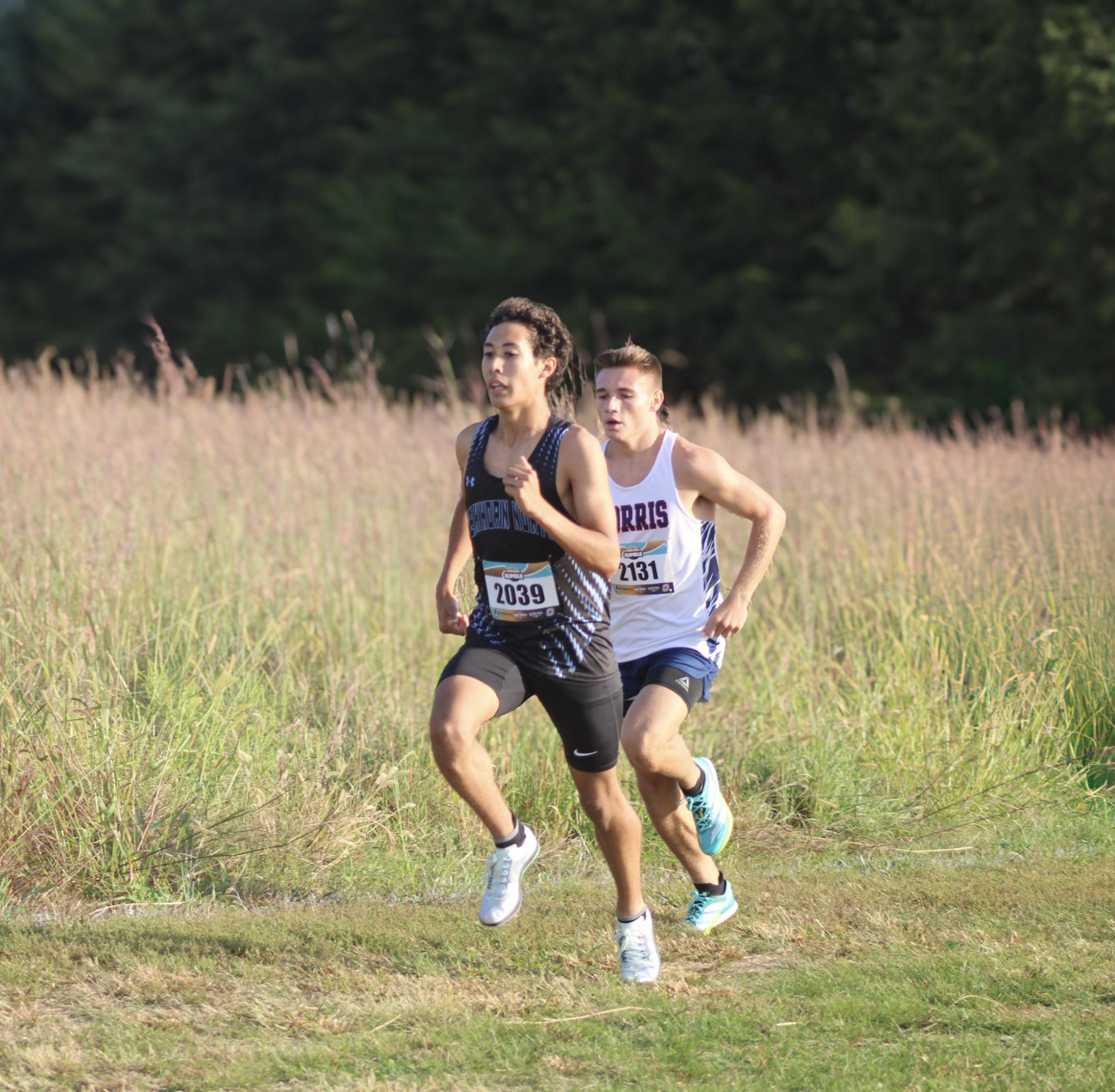 Senior Derek Rieck-Capellan maintains a steady pace while running the first 1K. Rieck-Capellan ended up earning a new personal best and school record with a time of 16:17.54.