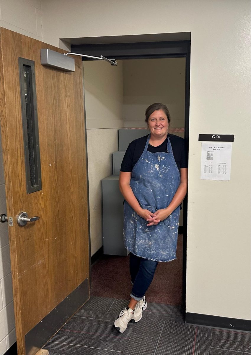 Traveling art teacher Nicole Lucks stands by her classroom door at Elkhorn High, one of two schools in which she teaches art.
Photo courtesy of Nicole Lucks