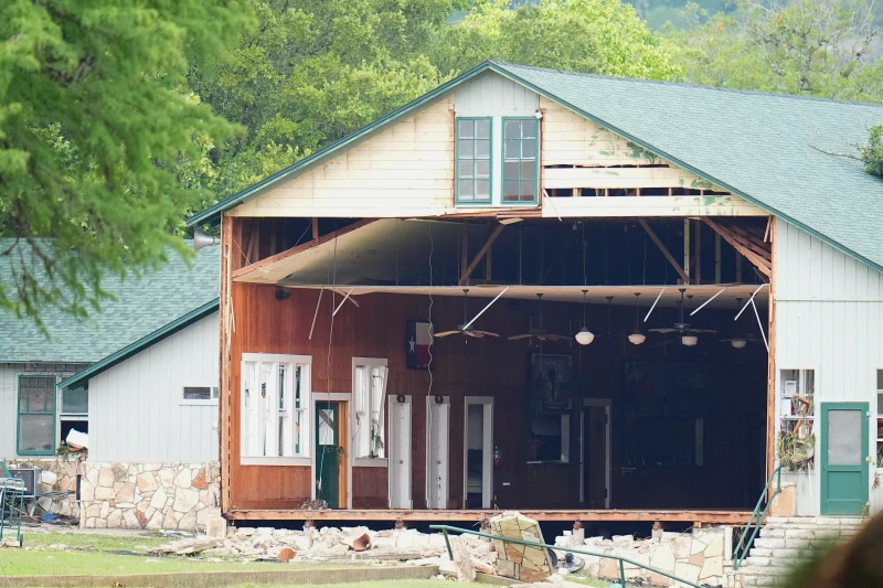 A full wall is missing from a Camp Mystic building after the Texas floods. The building is located near the Guadalupe River, where water rose over 20 feet during the flooding and affected many other buildings on camp property. Photo courtesy of Julio Cortez and AP Photo.