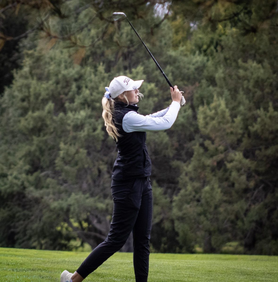 Junior Caylee Mack hits her second shot on hole two. Mack dealt with many factors like wind, lie, and fast greens throughout the tournament.